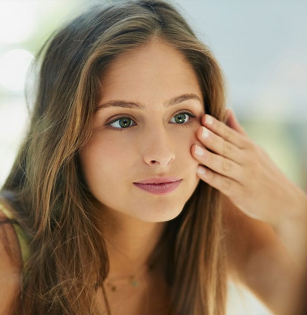woman looking in the mirror after her Intense Pulsed Light Therapy in St. Petersburg, FL